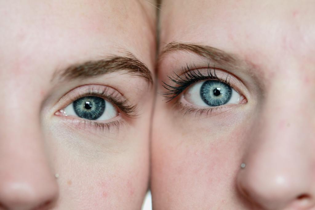 Close up of two women's faces, each showing one blue eye