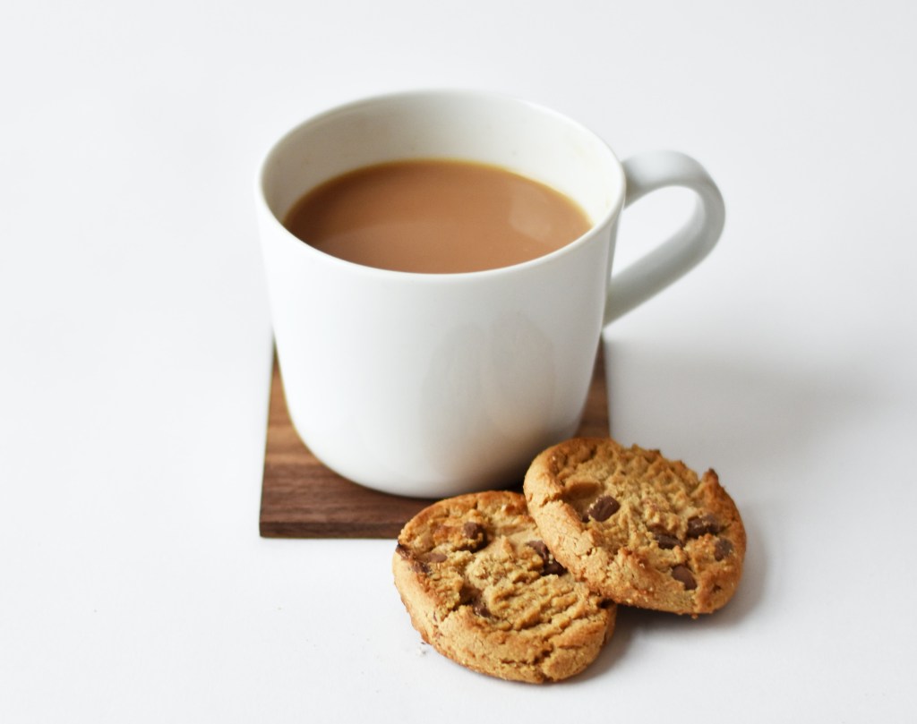 Cup of milky tea with two chocolate chip biscuits