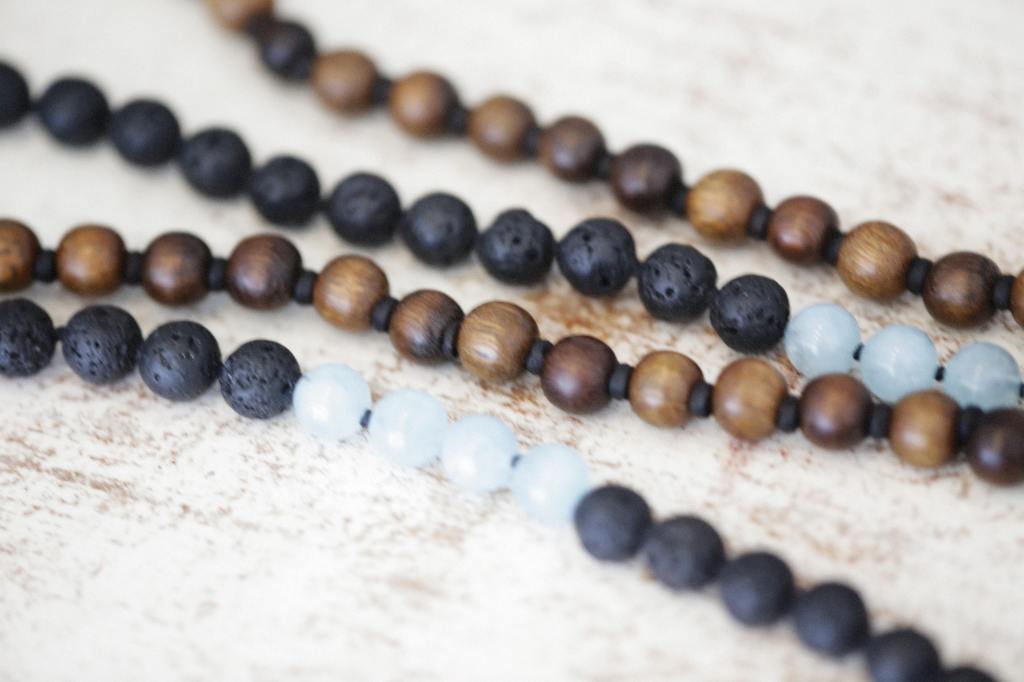 A string of wooden and glass beads on a painted wooden surface