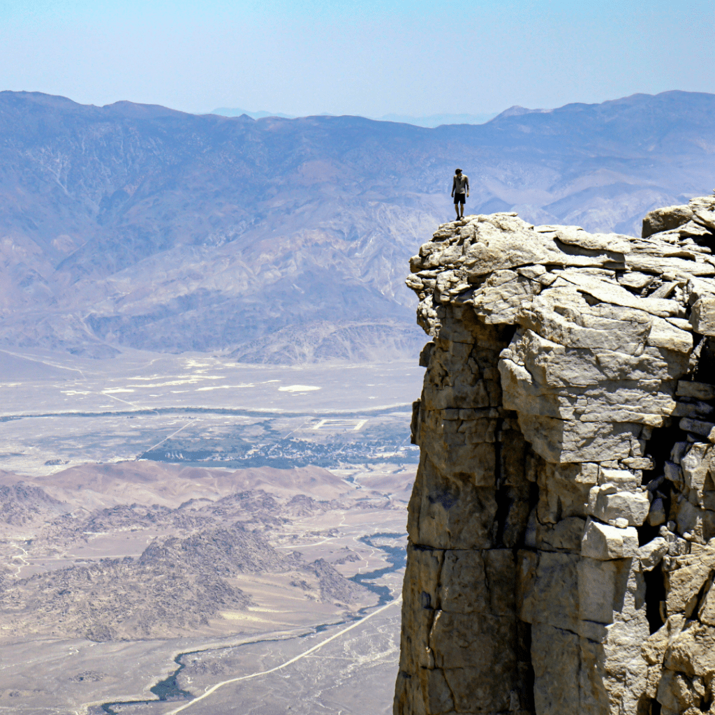 Person standing on top of a precipice.